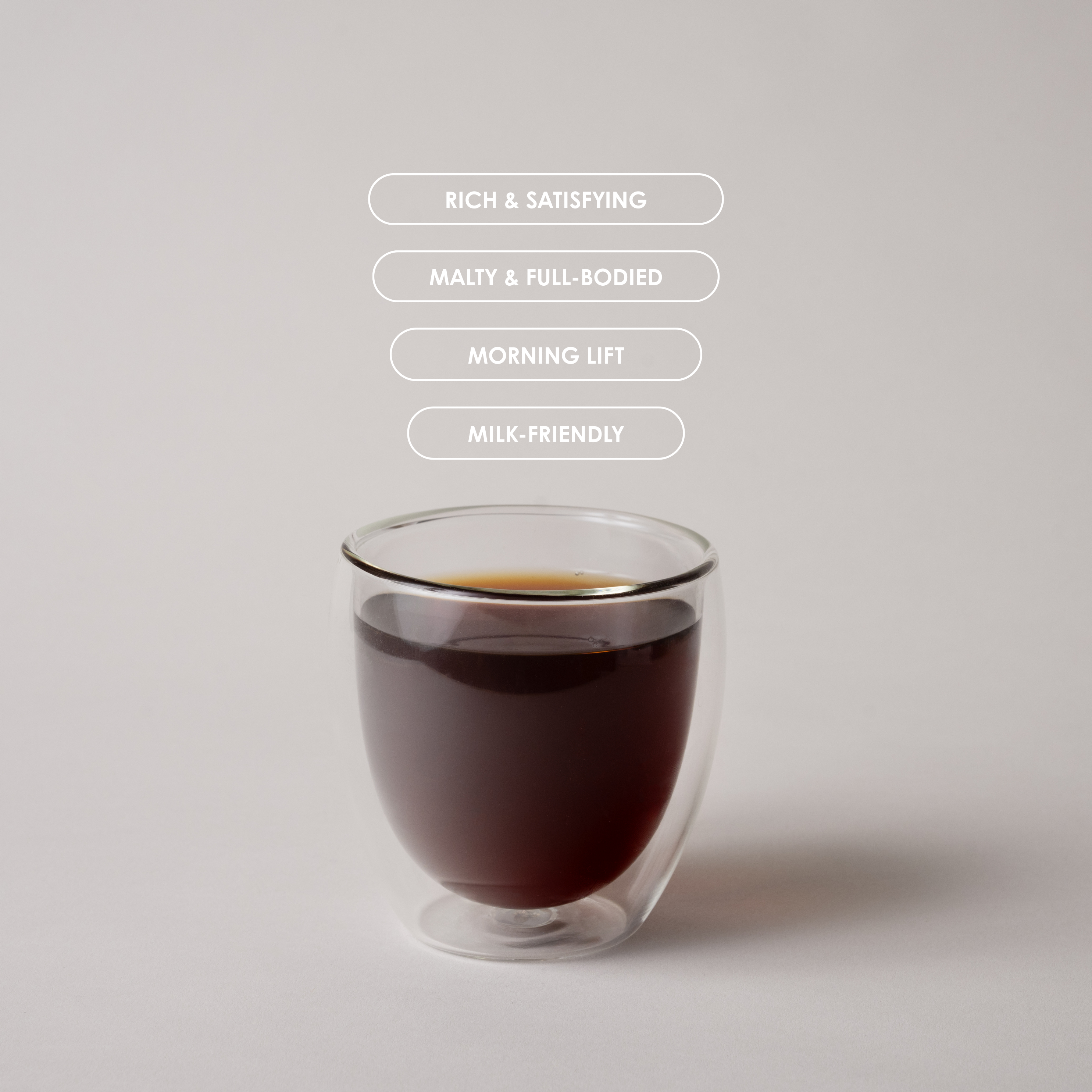 Glass of dark liquid with text describing its qualities on a light gray background