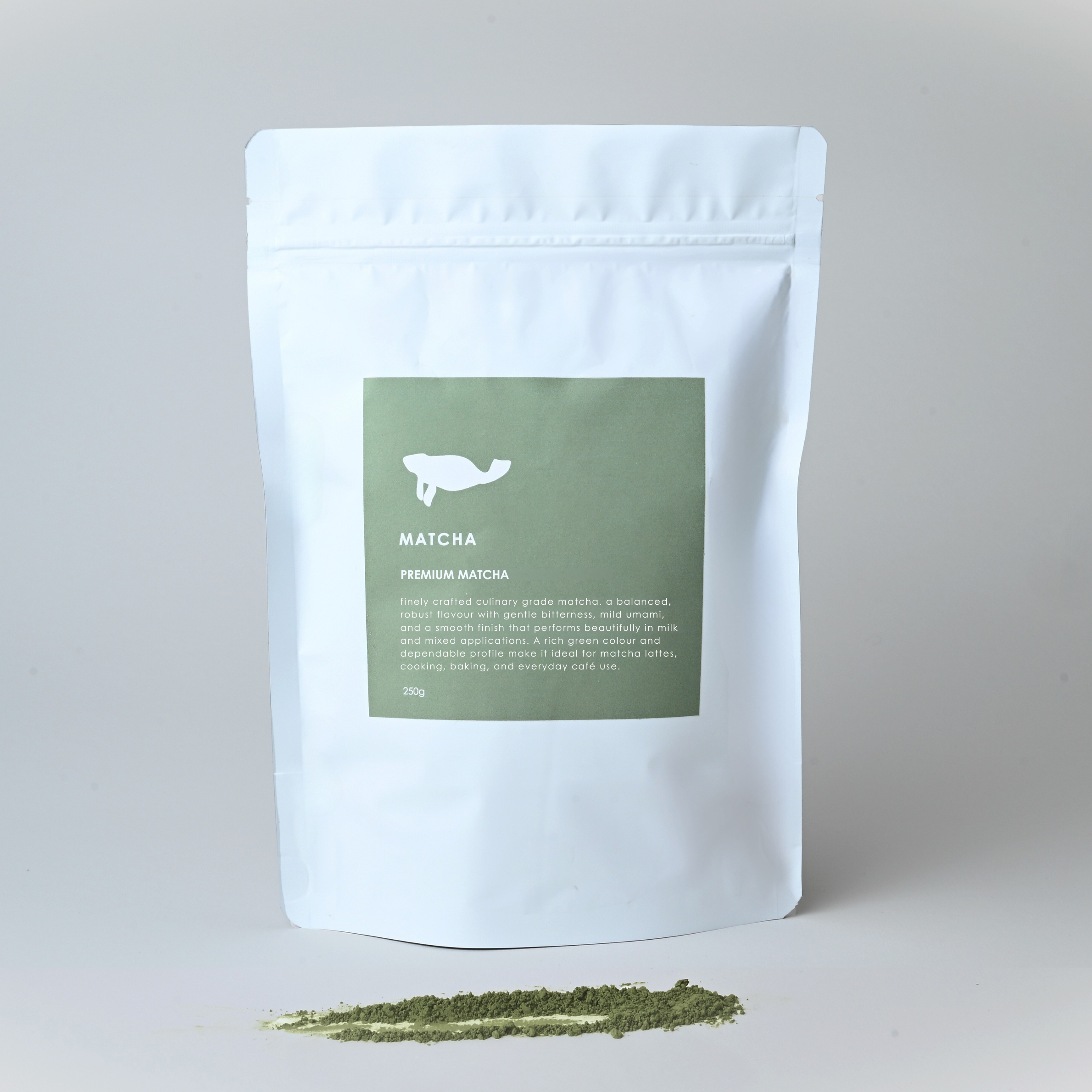 White packaging of matcha green tea powder with a green label on a light gray background.
